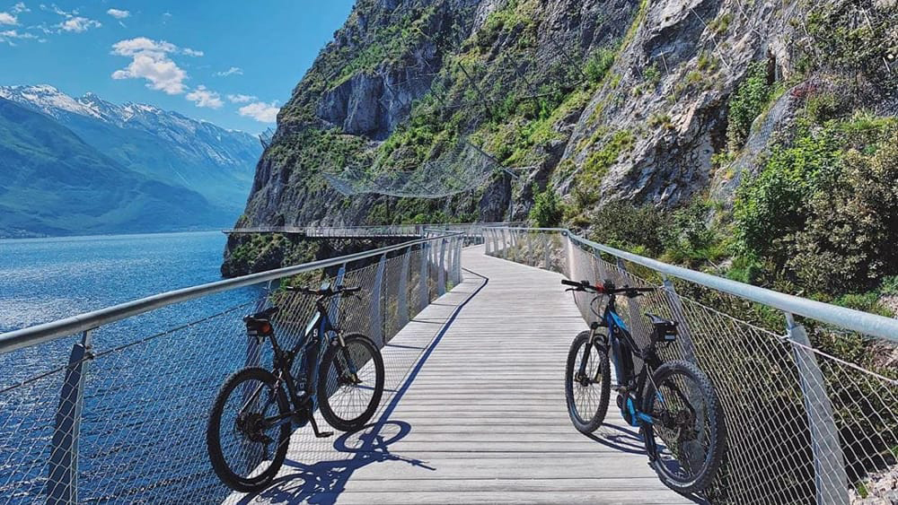 Biciclette sulla ciclopedonale del Garda sospesa sul lago a Limone